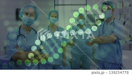 Standing medical professionals wearing blue scrubs and masks in hospital ward, with helix overlay 139254778