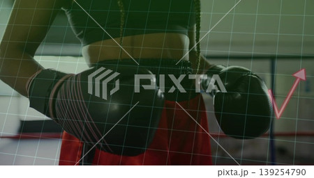 Raising fists female boxer wearing black gloves, red trunks in ring, green grid overlay, pink arrow Raising fists female boxer wearing black gloves, red trunks in ring, green grid overlay, pink arrow 139254790
