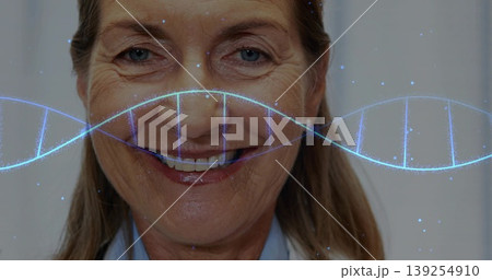 Smiling doctor wearing white lab coat over blue shirt in lab, featuring translucent blue DNA helix Smiling doctor wearing white lab coat over blue shirt in lab, featuring translucent blue DNA helix 139254910