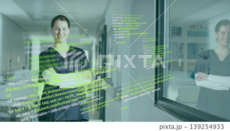 Smiling tech professional standing with arms crossed in office hallway, with floating code overlay 139254933