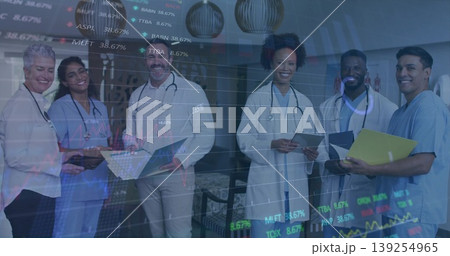 Standing medical team holding laptops and clipboards in lobby, with stethoscopes and stock charts Standing medical team holding laptops and clipboards in lobby, with stethoscopes and stock charts 139254965