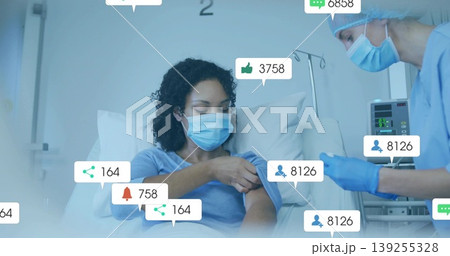 Attending nurse in scrubs administering shot to patient in hospital room, with social media icons Attending nurse in scrubs administering shot to patient in hospital room, with social media icons 139255328