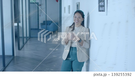 Business casual woman checking smartphone and glancing at smartwatch in office corridor, copy space 139255392