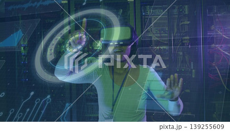 Manipulating holographic interface wearing VR headset at data center, with server racks and cables 139255609