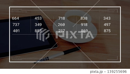 Displaying black tablet showing numeric overlay on wood table, coffee cup, saucer, pen, copy space 139255696