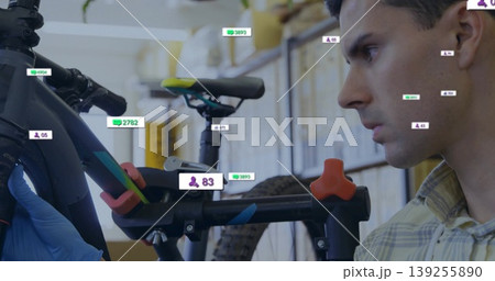 Inspecting mechanic wearing yellow shirt gloves adjusting bike frame in garage overlays, copy space 139255890