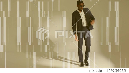 Posing mid adult man wearing dark suit and sunglasses leaning in studio, with glitch effect lights Posing mid adult man wearing dark suit and sunglasses leaning in studio, with glitch effect lights 139256026