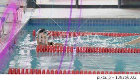 Holding red lane divider, female swimmer wearing swim cap and goggles, gazing ahead in swim lane Holding red lane divider, female swimmer wearing swim cap and goggles, gazing ahead in swim lane 139256032