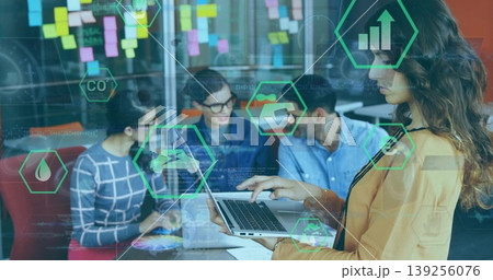 Leading businesswoman wearing mustard blazer holding laptop in office with sticky notes, copy space Leading businesswoman wearing mustard blazer holding laptop in office with sticky notes, copy space 139256076