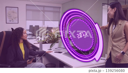 Discussing coworkers pointing at purple 2013 hologram on office desk with monitor laptop and tablet Discussing coworkers pointing at purple 2013 hologram on office desk with monitor laptop and tablet 139256080
