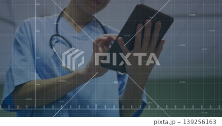 Navigating data grid, nurse in blue scrubs with stethoscope tapping tablet in hospital corridor Navigating data grid, nurse in blue scrubs with stethoscope tapping tablet in hospital corridor 139256163