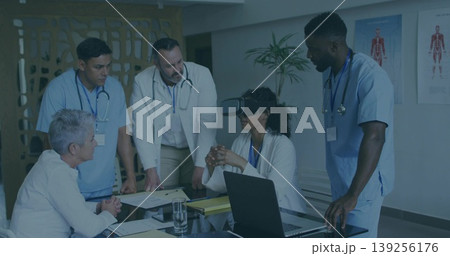 Observing female doctor wearing virtual reality headset at hospital meeting room, with stethoscopes Observing female doctor wearing virtual reality headset at hospital meeting room, with stethoscopes 139256176