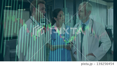 Analyzing medical professionals viewing digital charts in hospital corridor with tablet stethoscope 139256454