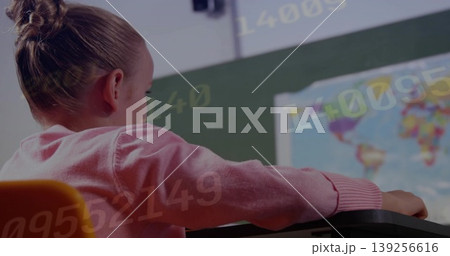 Girl student wearing sweater sitting at desk in class facing chalkboard with world map, copy space Girl student wearing sweater sitting at desk in class facing chalkboard with world map, copy space 139256616