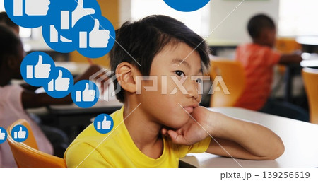 Elementary boy leaning on desk while gazing in class, with orange chairs and blue thumbs-up icons Elementary boy leaning on desk while gazing in class, with orange chairs and blue thumbs-up icons 139256619