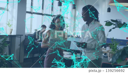 Collaborating professionals using laptop and smartphone at office, network graphics overlay 139256692
