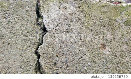 Cracked Concrete Wall with Moss Texture Shows Urban Weathering and Rough Surface 139256789