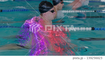 Cutting lead swimmer with black cap and tinted goggles breaststroking in pool with particle effect 139256823
