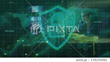 Woman reviewing cybersecurity data in dimly lit office, with glowing teal shield icon overlay Woman reviewing cybersecurity data in dimly lit office, with glowing teal shield icon overlay 139256992