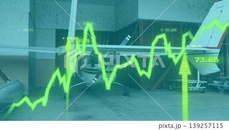 Displaying white propeller airplane resting inside hangar bay, with green digital graph overlay 139257115
