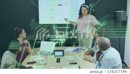 Pointing presenter in blouse and trousers showing charts in boardroom, digital overlay, copy space Pointing presenter in blouse and trousers showing charts in boardroom, digital overlay, copy space 139257146