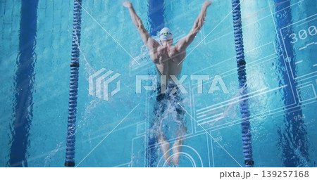 Gliding swimmer in goggles creating splashes in lap pool, with lane dividers and digital overlay 139257168