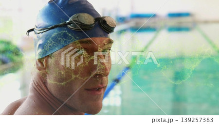 Standing swimmer wearing blue cap and black goggles at pool lanes with network overlay, copy space 139257383