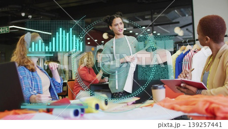 Presenting designer holding pastel pink blouse sample at design studio table, holographic overlays Presenting designer holding pastel pink blouse sample at design studio table, holographic overlays 139257441