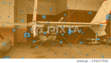 Showing propeller airplane inside hangar doors, dinghy, cart and semi-transparent icons overlay Showing propeller airplane inside hangar doors, dinghy, cart and semi-transparent icons overlay 139257502