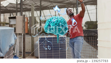 Raising arm male technician leaning on solar panel in greenhouse toward turquoise brain hologram 139257783