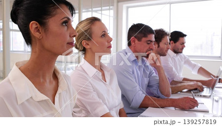 Sitting five professionals in business casual at office meeting room, with notebooks and laptops Sitting five professionals in business casual at office meeting room, with notebooks and laptops 139257819