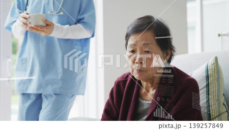 Caregiver in scrubs offering bowl and spoon in living room, with stethoscope and striped cushion 139257849
