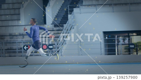 Sprinting teenage athlete with prosthetic blades and sports watch on stadium track lane, copy space Sprinting teenage athlete with prosthetic blades and sports watch on stadium track lane, copy space 139257980