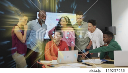 Collaborating seven professionals reviewing wall display data in boardroom with laptops and reports Collaborating seven professionals reviewing wall display data in boardroom with laptops and reports 139257986