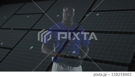 Standing man wearing blue baseball jersey with white pants in grid studio, holding baseball glove Standing man wearing blue baseball jersey with white pants in grid studio, holding baseball glove 139258003