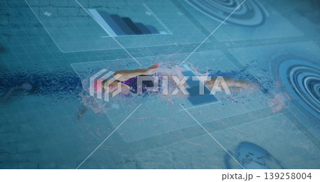 Female swimmer gliding in training pool lane with pink cap, goggles, swimsuit and digital overlays Female swimmer gliding in training pool lane with pink cap, goggles, swimsuit and digital overlays 139258004