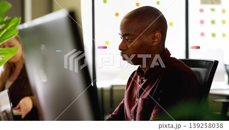 Reviewing colleague with burgundy shirt viewing monitor in office, with sticky notes, copy space Reviewing colleague with burgundy shirt viewing monitor in office, with sticky notes, copy space 139258038
