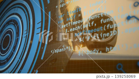 Camera lens resting on studio desk in warm light with semi-transparent blue concentric code overlay Camera lens resting on studio desk in warm light with semi-transparent blue concentric code overlay 139258069