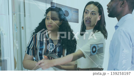 Analyzing data team wearing business attire using glass panel in office, holding tablet and stylus Analyzing data team wearing business attire using glass panel in office, holding tablet and stylus 139258197