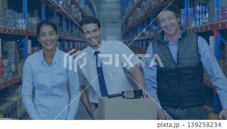 Standing staff inspecting cardboard box on pallet in aisle, with tape dispenser and metal shelving 139258234