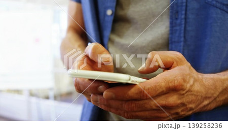 Tapping middle-aged man's fingers swiping smartphone touchscreen in retail area, with blue shirt Tapping middle-aged man's fingers swiping smartphone touchscreen in retail area, with blue shirt 139258236