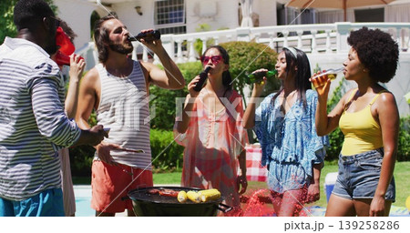 Group of six friends grilling in backyard beside pool, with beer bottles, corn, sausages Group of six friends grilling in backyard beside pool, with beer bottles, corn, sausages 139258286