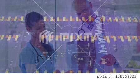 Examining nurse and doctor analyzing data in corridor, with stethoscopes, clipboard and charts 139258323
