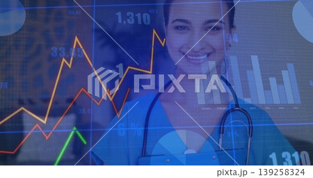 Smiling Dr wearing scrubs holding tablet and stethoscope in hospital with chart overlay, copy space Smiling Dr wearing scrubs holding tablet and stethoscope in hospital with chart overlay, copy space 139258324