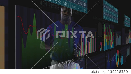 Man wearing blue T-shirt analyzing data on panels at trading floor, with floating financial charts Man wearing blue T-shirt analyzing data on panels at trading floor, with floating financial charts 139258580