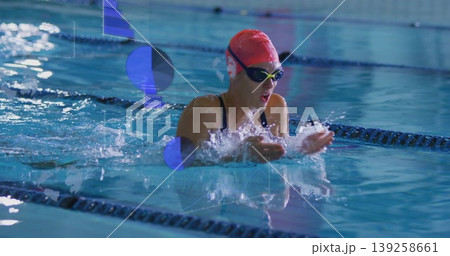 Gliding swimmer raising head pressing hands at pool lane, with silicone cap and mirrored goggles 139258661