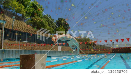 Diving male athlete wearing swim briefs plunging off block at outdoor pool with digital overlay 139258703