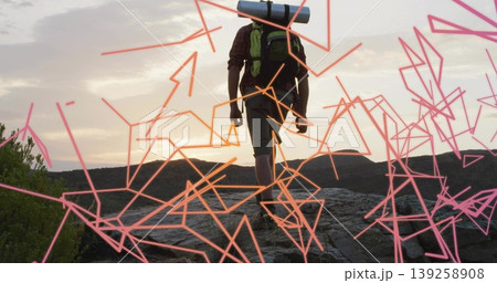 Climbing male hiker wearing hiking boots on rocky ridge at dawn, with backpack, neon lines Climbing male hiker wearing hiking boots on rocky ridge at dawn, with backpack, neon lines 139258908