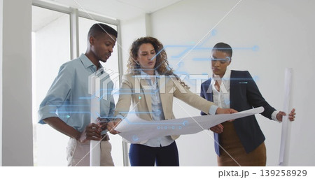 Examining team wearing blazers reviewing blueprint in office, with rolled plans tech overlay Examining team wearing blazers reviewing blueprint in office, with rolled plans tech overlay 139258929