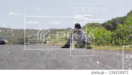 Sitting Indian woman in tee on asphalt road shoulder showing data overlays with car, shrubs Sitting Indian woman in tee on asphalt road shoulder showing data overlays with car, shrubs 139258971